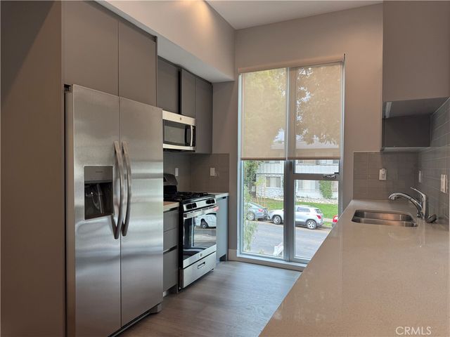 a kitchen with stainless steel appliances granite countertop a refrigerator and a sink
