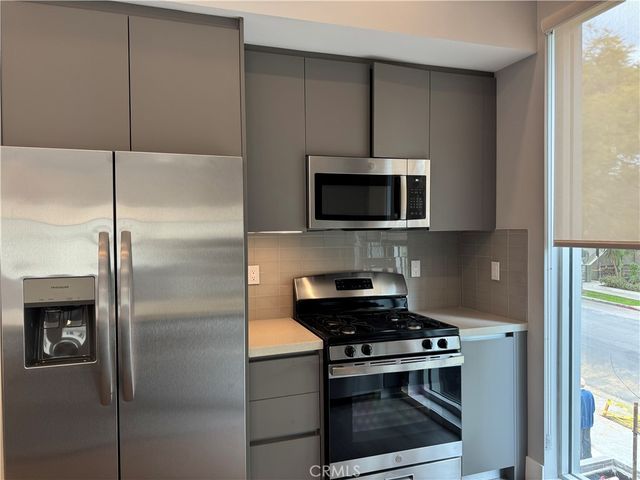 a kitchen with stainless steel appliances a refrigerator and a stove top oven