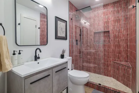 a bathroom with a sink a toilet and shower