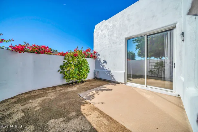a flower garden in front of a white house
