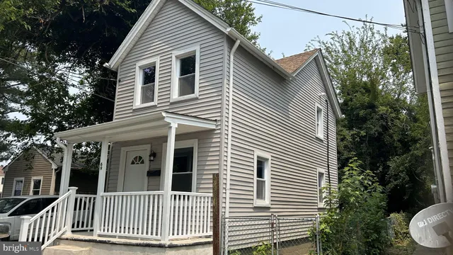 a view of a house with a small window and potted plants