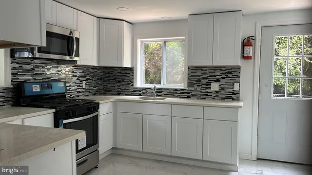 a kitchen with stainless steel appliances granite countertop a stove sink and microwave