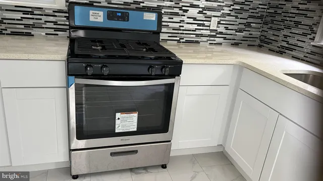 a stove top oven sitting inside of a kitchen