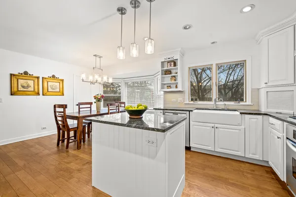 a kitchen with stainless steel appliances granite countertop a sink a stove top oven a counter space and living room view
