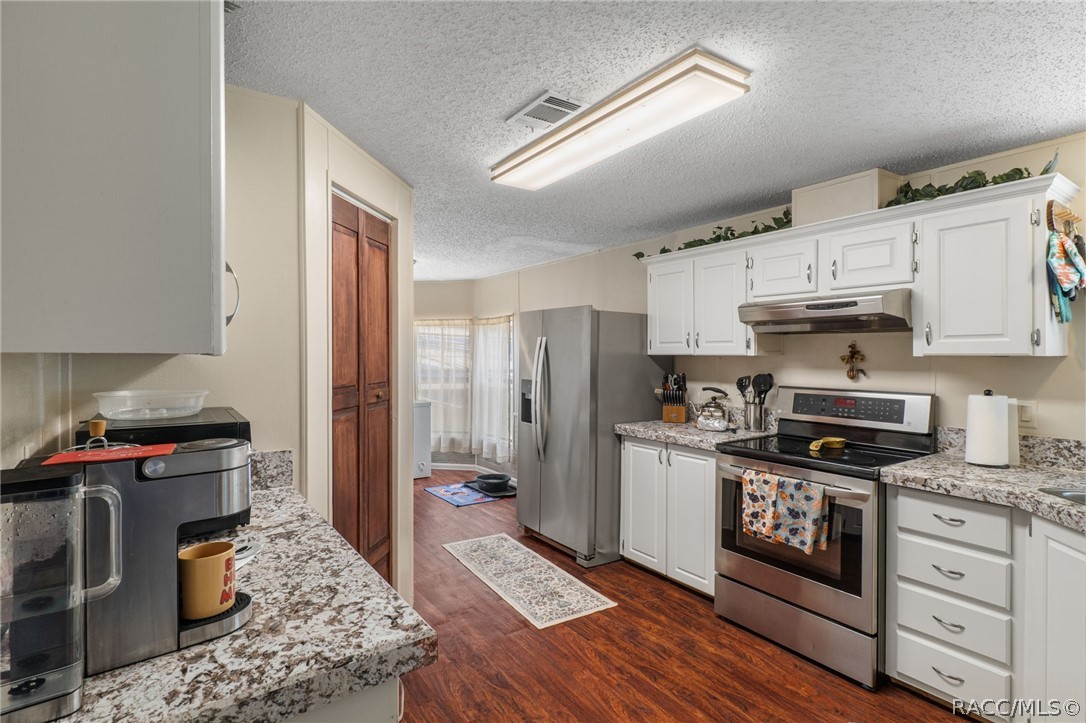7927 West Cyprian Court Homosassa, FL 34448 - Photo 11 of 40 a kitchen with stainless steel appliances granite countertop a stove refrigerator sink and microwave