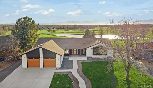 a aerial view of a house next to a big yard and large trees