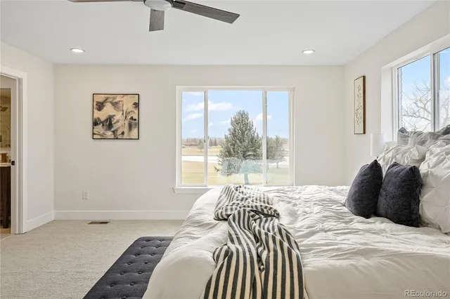 a bedroom with a bed and a large window