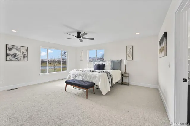 a bedroom with a large bed chandelier and a window