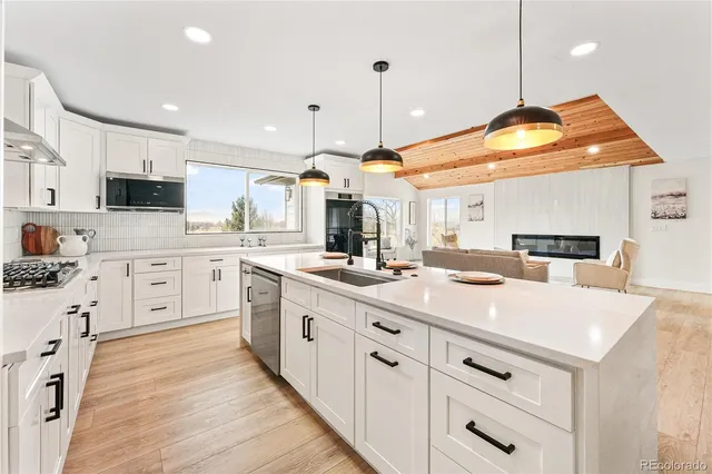 a kitchen with kitchen island a sink appliances and cabinets