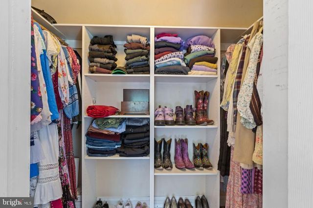 a view of walk in closet with clothes and shoes