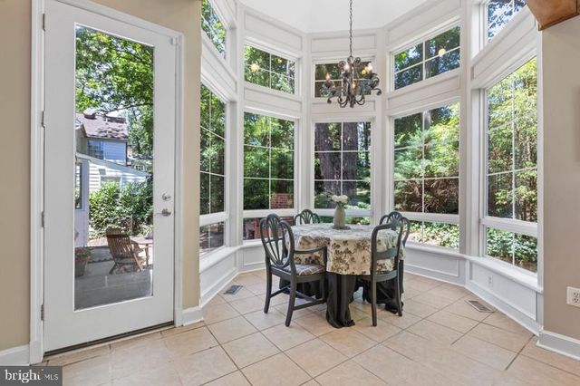 a dining room with furniture large windows and a chandelier