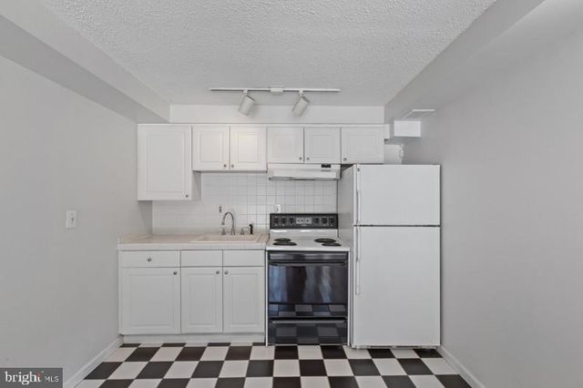 a kitchen with stainless steel appliances a stove a sink and a refrigerator