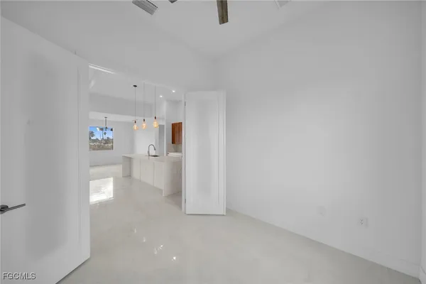 a view of an empty room with a kitchen