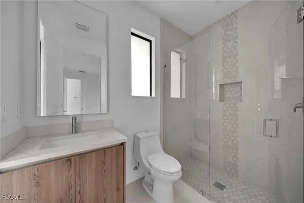 a bathroom with a sink a toilet and shower