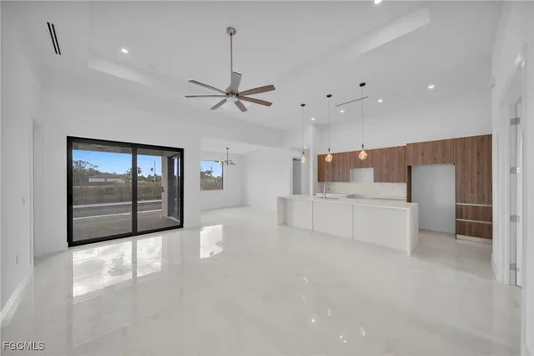 a large white room with a large window and stainless steel appliances