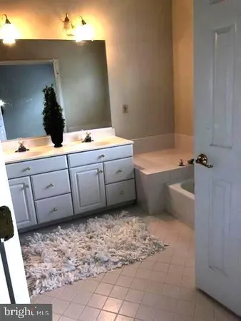 a bathroom with a tub sink and mirror