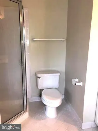 a white toilet sitting next to a shower