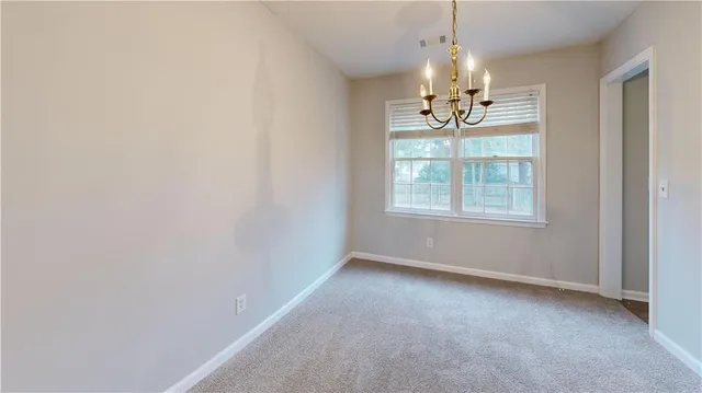 an empty room with windows and chandelier