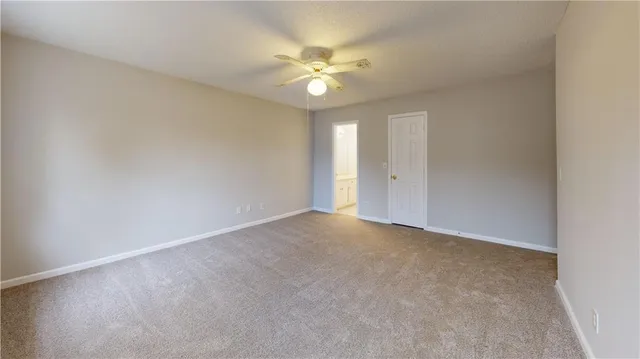 a view of an empty room with a chandelier fan