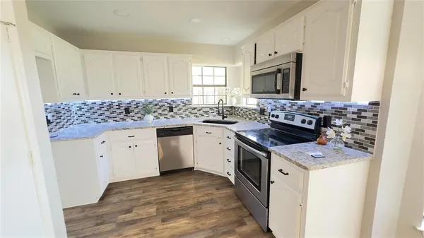 a kitchen with stainless steel appliances granite countertop a stove and a sink