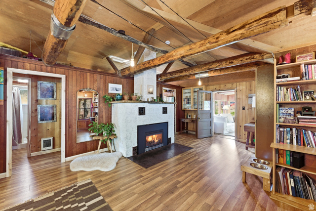 6631 Pine Springs Road Kamas, UT 84036 - Photo 19 of 48 Living room with wood walls, wood finished floors, beam ceiling, and a tile fireplace