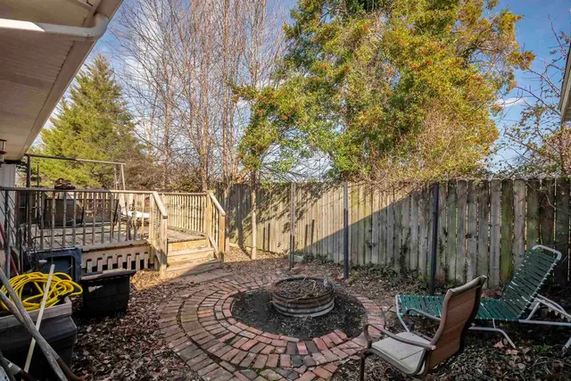 a view of a patio with table and chairs potted plants and wooden fence