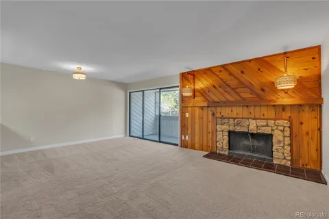 a view of an empty room with a fireplace and a window