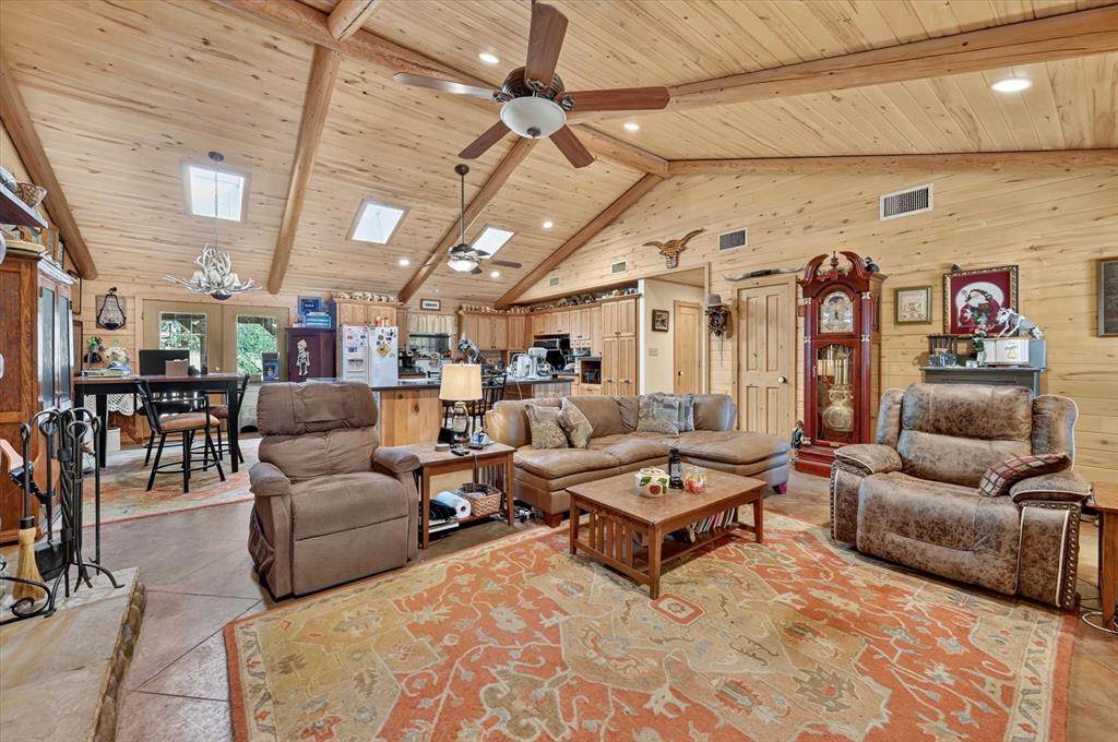 1623 3 Skillet Road Springtown, TX 76082 - Photo 7 of 40 Vaulted wood-paneled ceiling with exposed beams, multiple skylights, and ceiling fans
