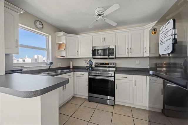a kitchen with granite countertop a sink stainless steel appliances and cabinets