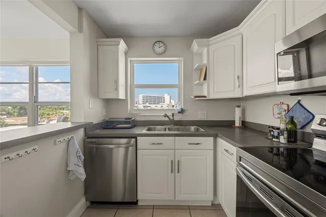 a kitchen with stainless steel appliances granite countertop a sink and cabinets with wooden floor