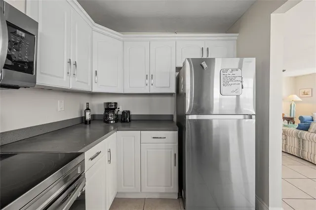 a kitchen with a refrigerator sink and cabinets