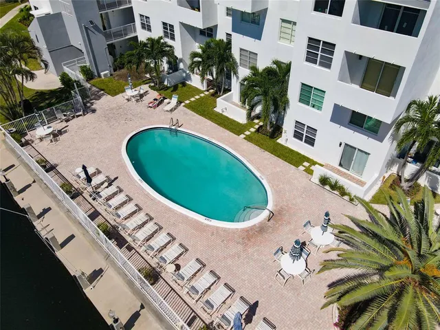 an aerial view of a swimming pool with outdoor seating and yard