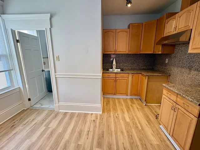 a view of a kitchen with wooden floor and a sink