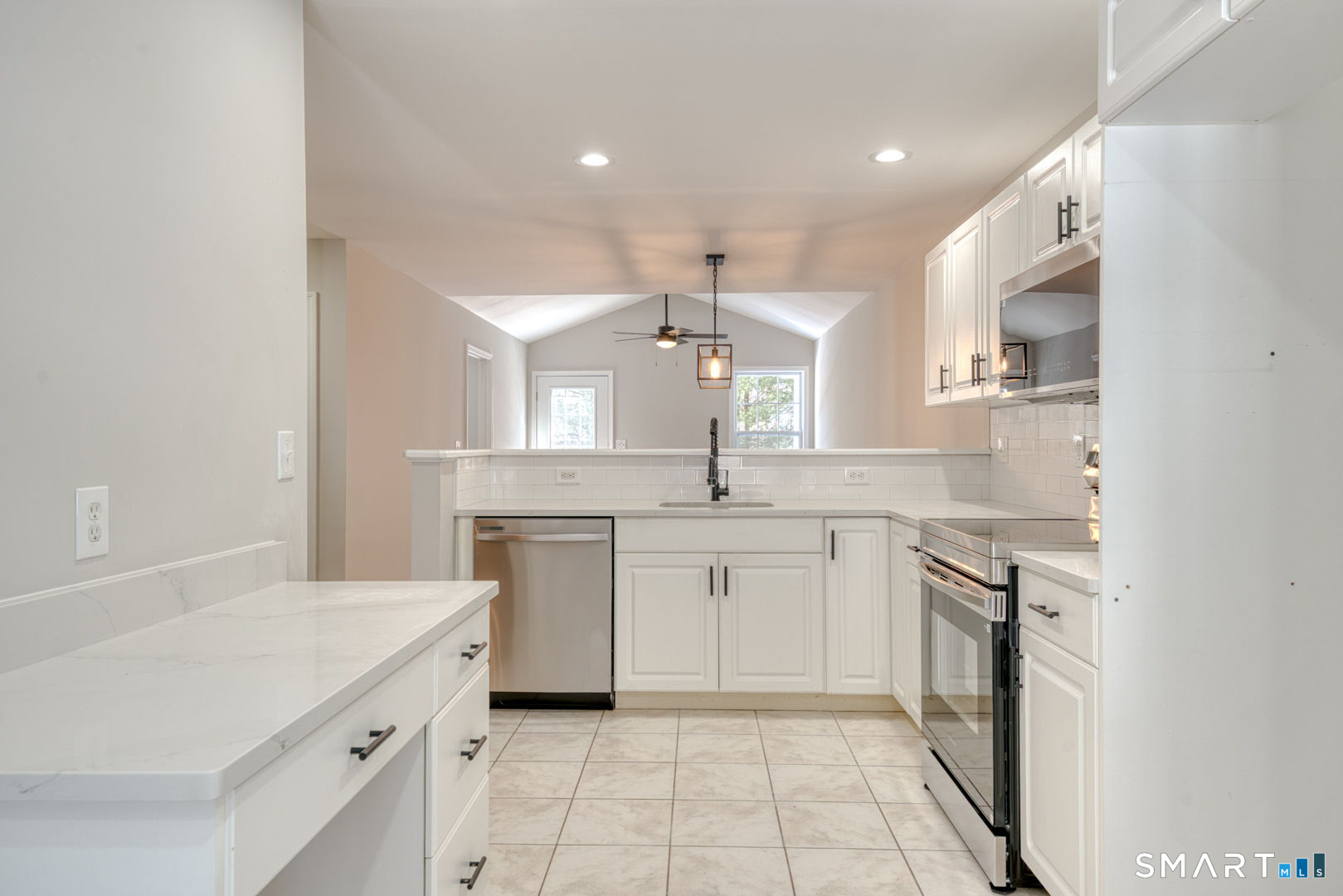 159 Jennifer Lane, Unit 159 Newtown, CT 06482 - Photo 14 of 28 a large kitchen with a sink dishwasher a stove and white cabinets with wooden floor