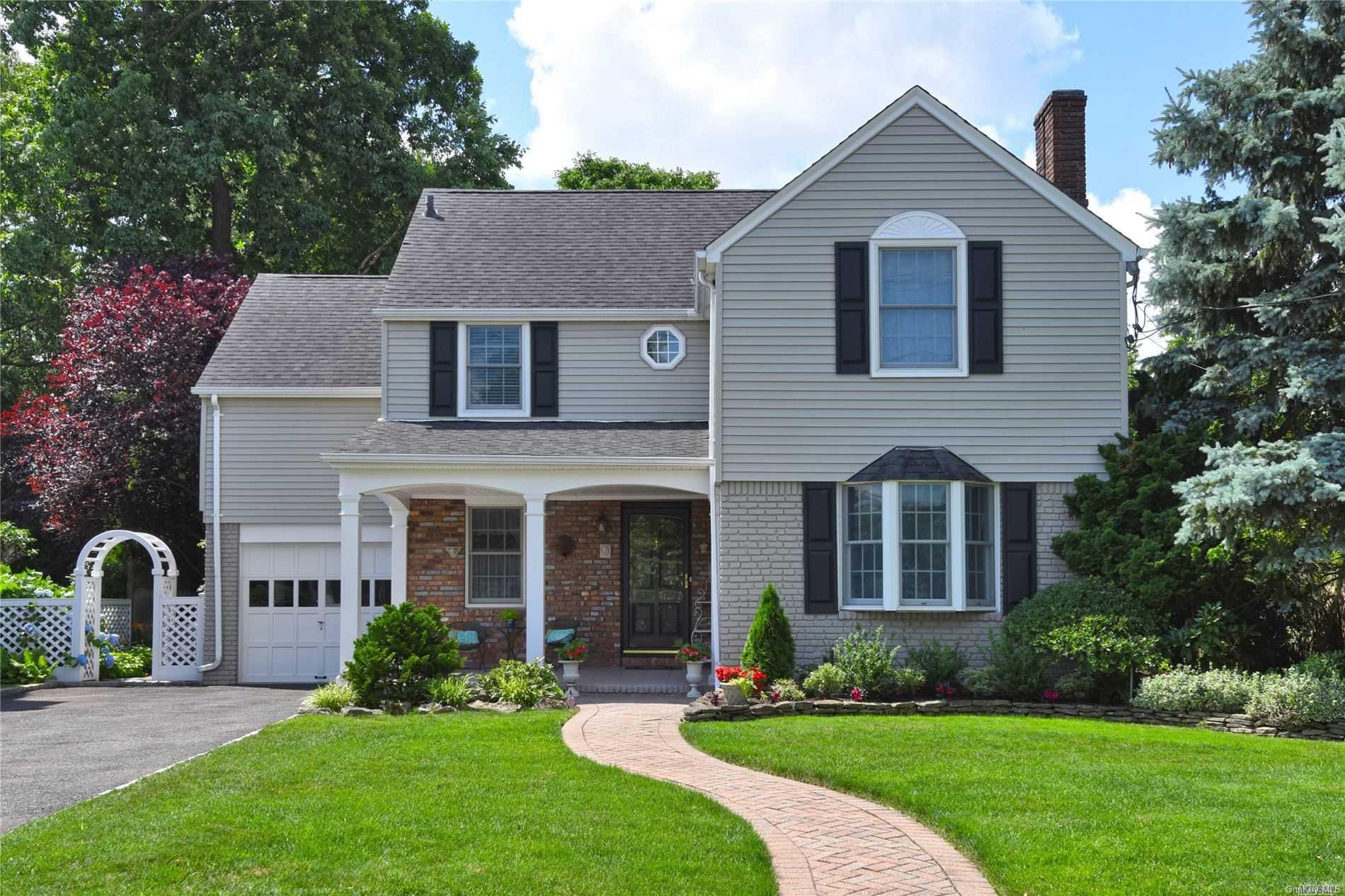 84 Fonda Road Rockville Centre, NY 11570 - Photo 1 of 1 a front view of a house with a yard and garage