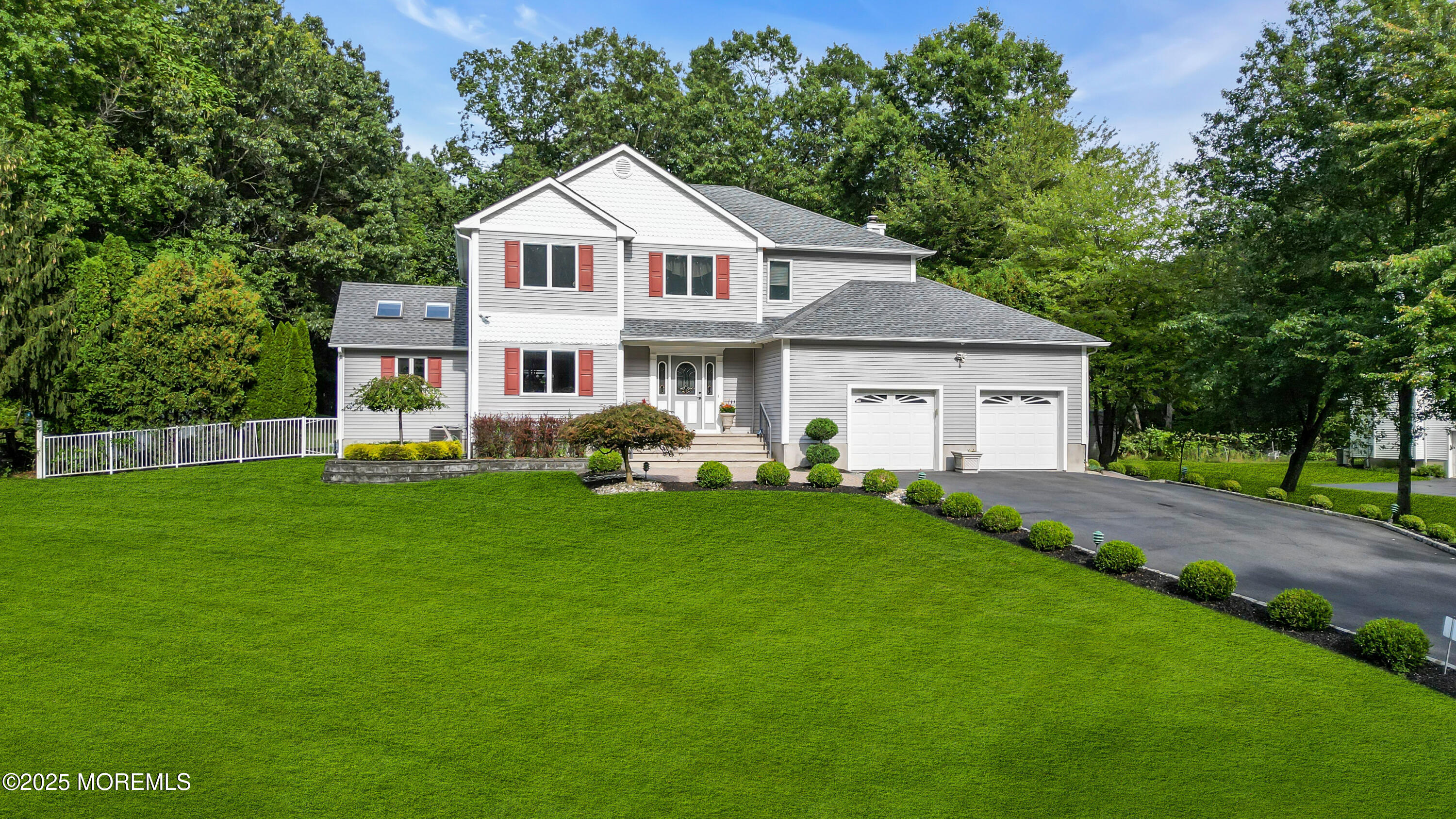 a front view of a house with a garden and trees