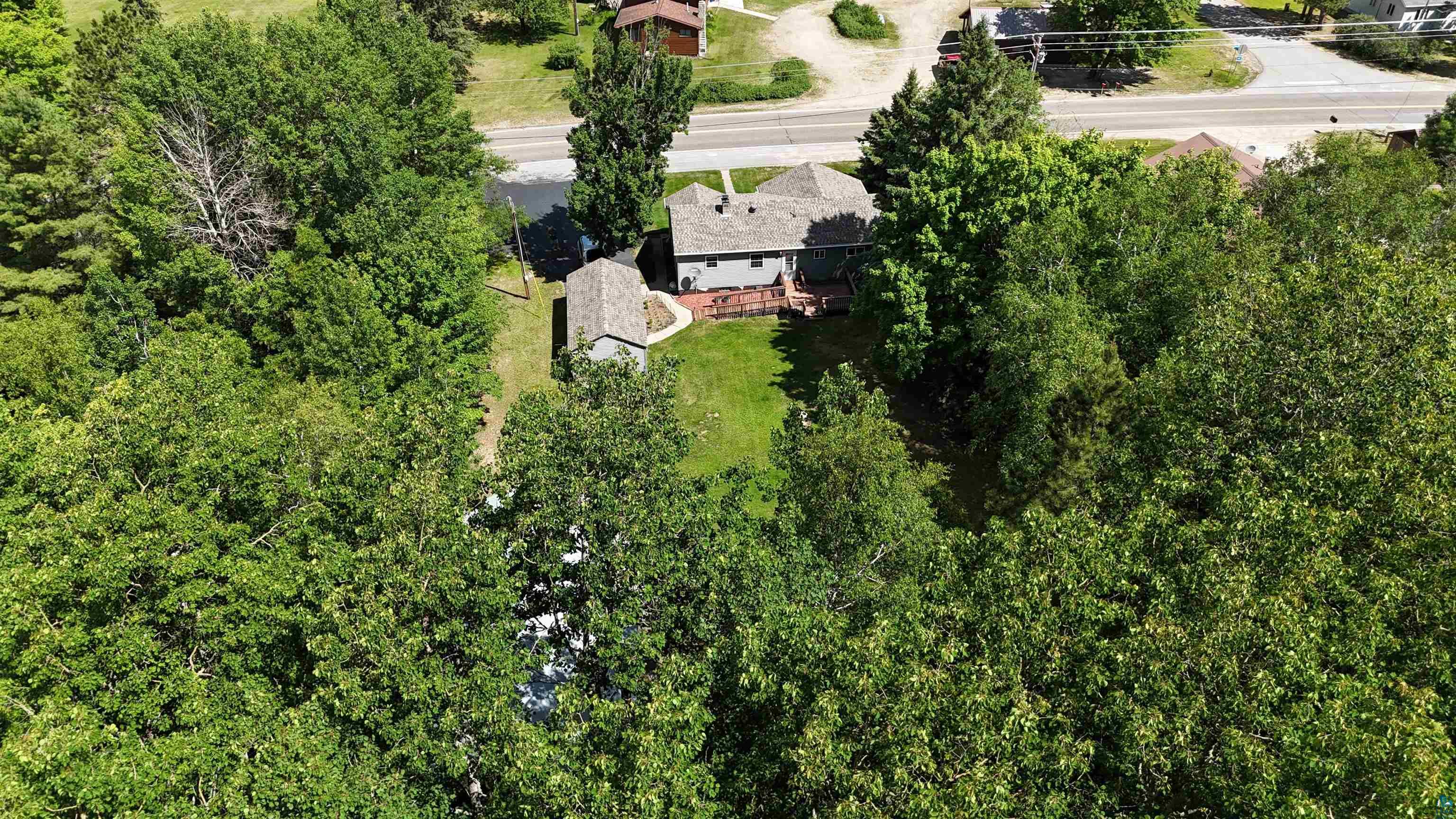 10614 Moose Lake Road Orr, MN 55771 - Photo 8 of 44 Property with a surrounding canopy of mature trees, featuring a gray-toned residence with a gabled roofline