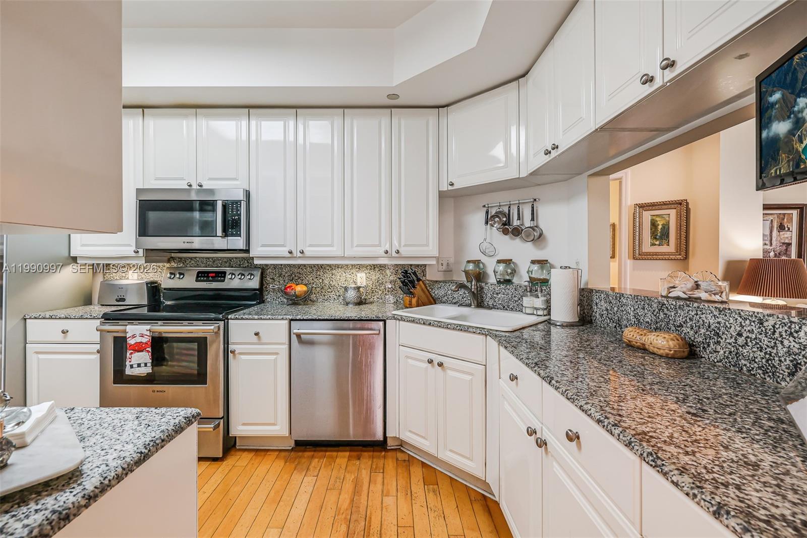 888 Brickell Key Drive, Unit 807 Miami, FL 33131 - Photo 18 of 62 a kitchen with stainless steel appliances granite countertop a stove a sink and a microwave