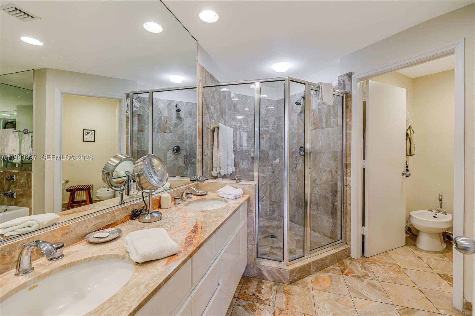 888 Brickell Key Drive, Unit 807 Miami, FL 33131 - Photo 36 of 62 a bathroom with a double vanity sink toilet and shower
