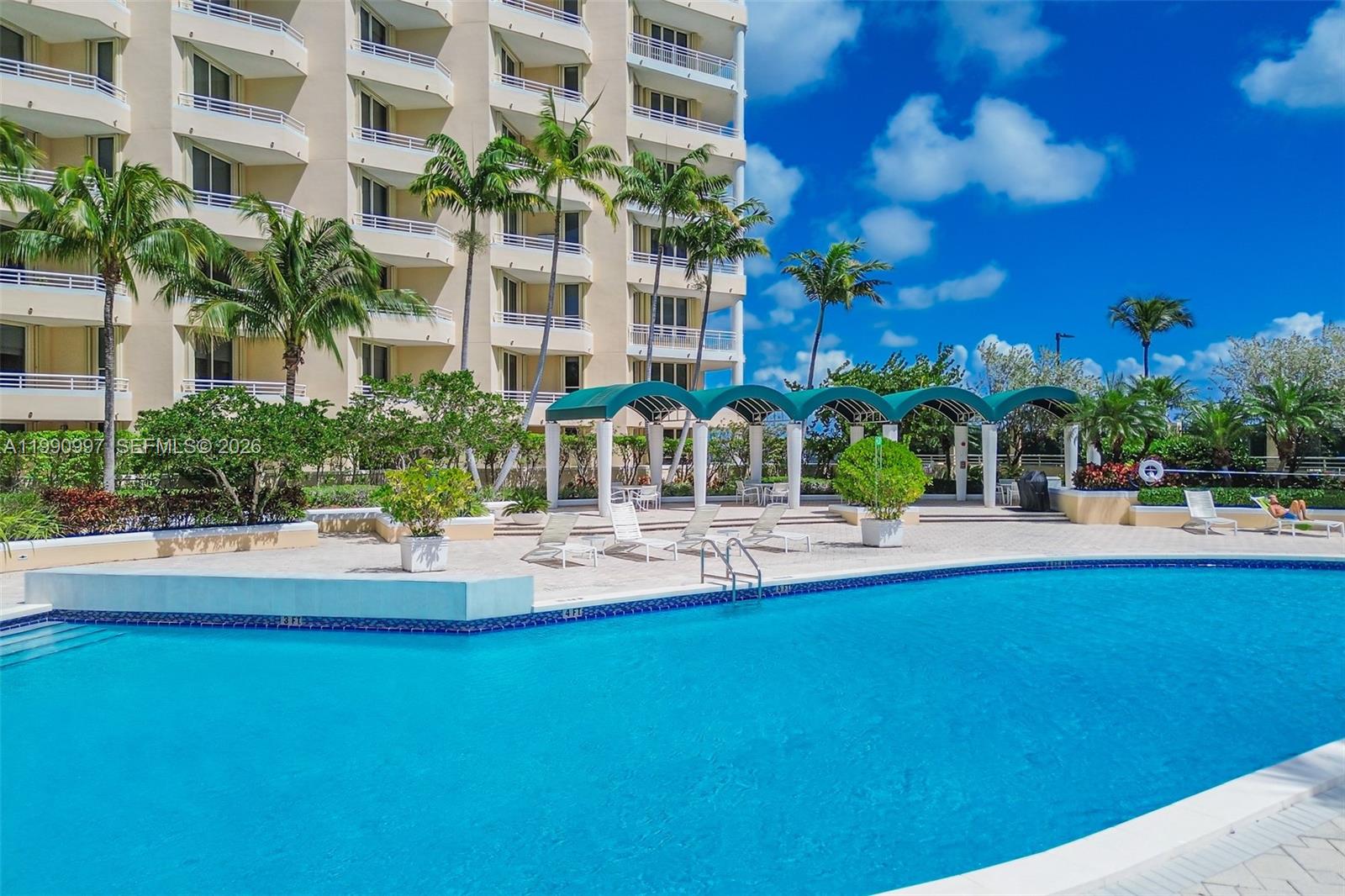 888 Brickell Key Drive, Unit 807 Miami, FL 33131 - Photo 59 of 62 a view of swimming pool with outdoor seating and house in the background