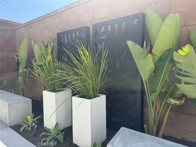 a vase of flowers sitting on a table with chairs and wooden floor