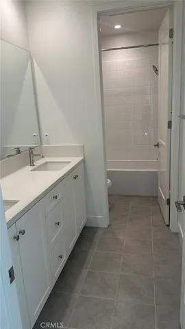 a bathroom with a double vanity sink a toilet and a bathtub
