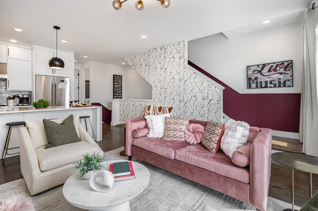 a living room with furniture kitchen view and a potted plant