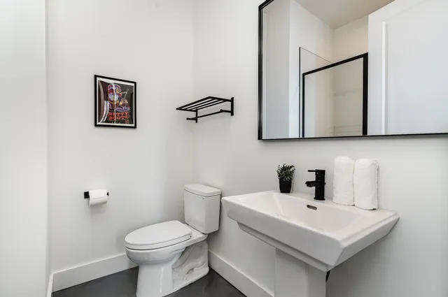 a bathroom with a toilet sink and mirror
