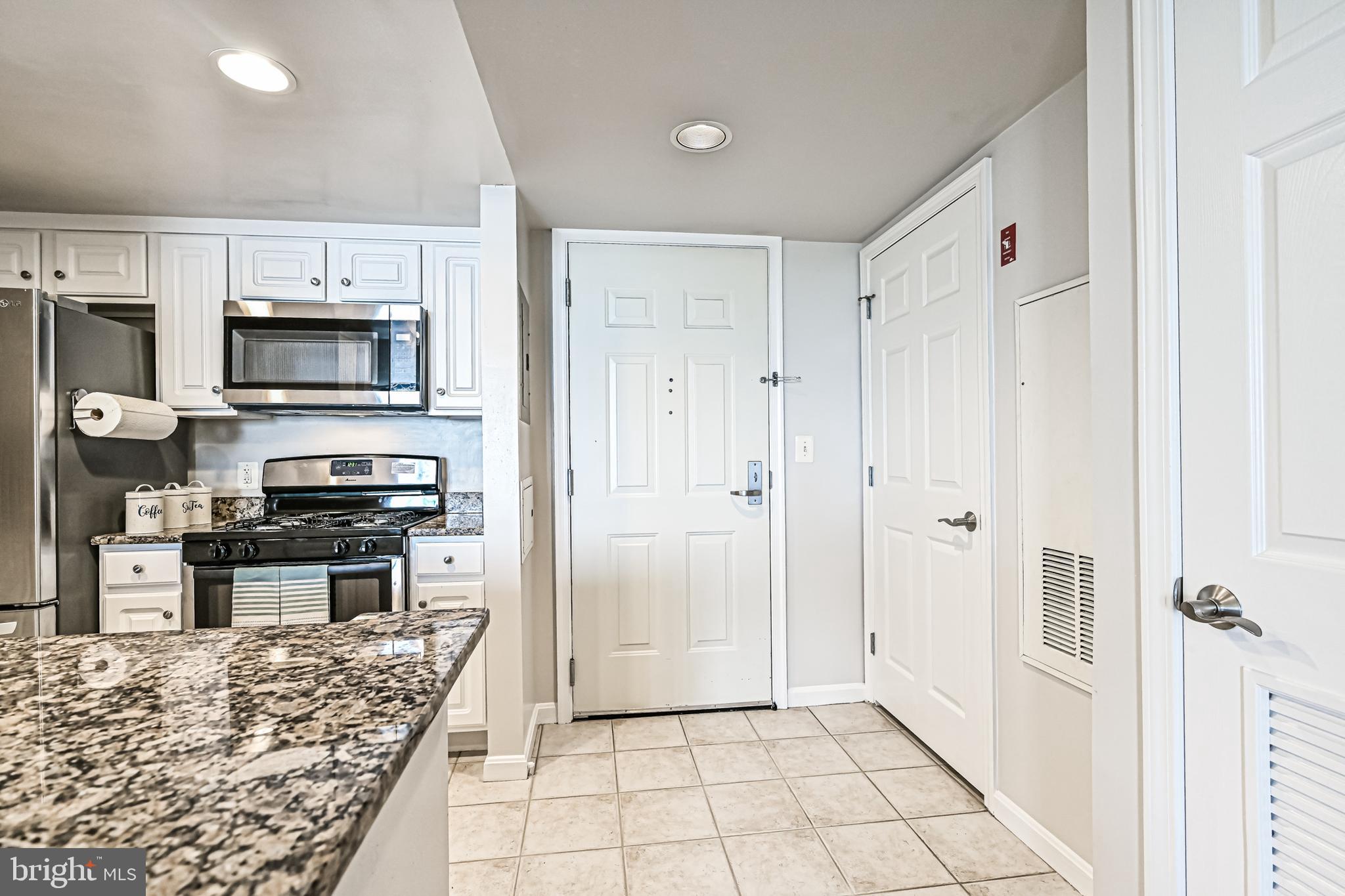 11710 Old Georgetown Road, Unit 1212 Rockville, MD 20852 - Photo 23 of 55 a kitchen with stainless steel appliances granite countertop a refrigerator and a stove top oven