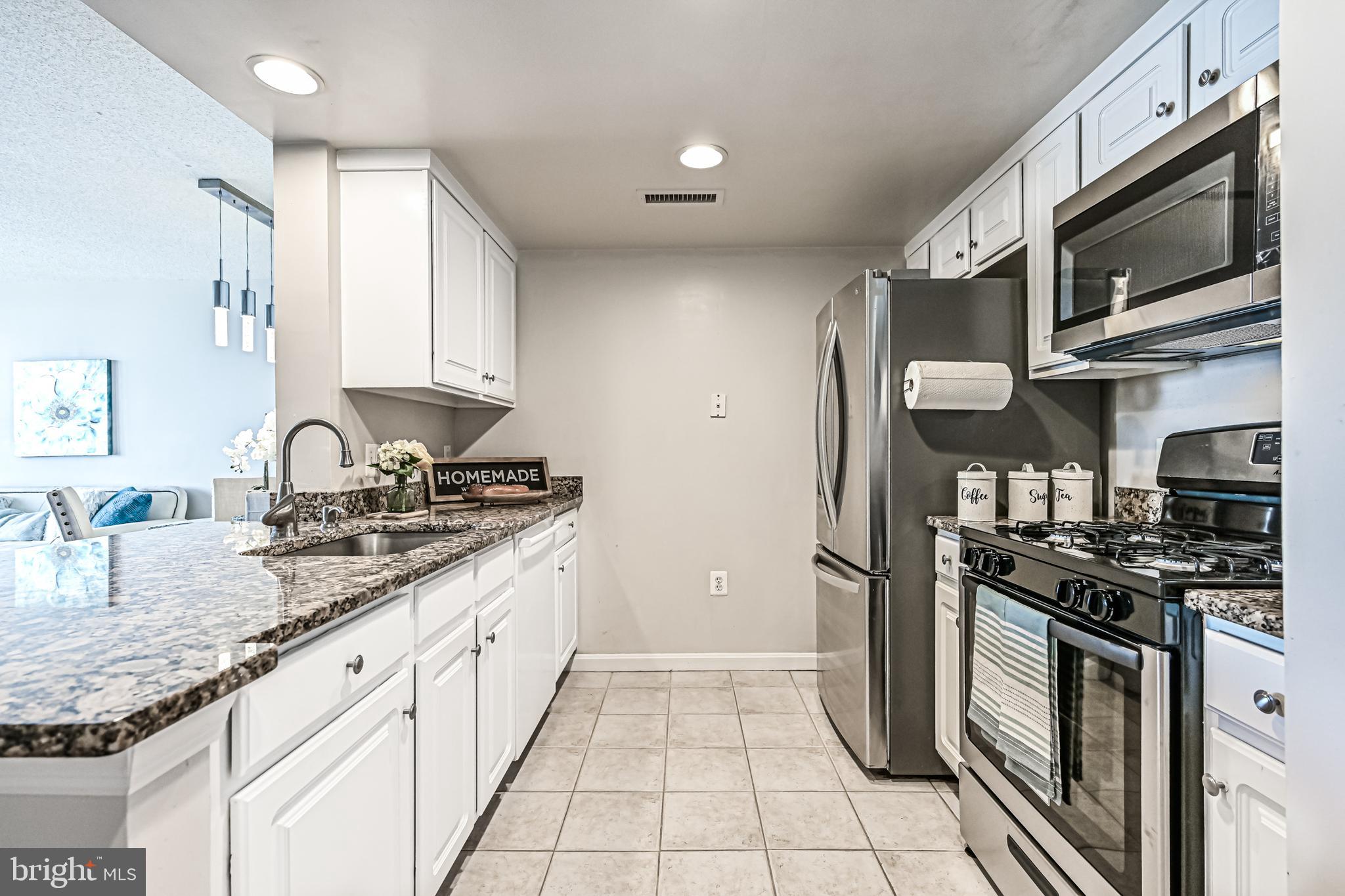 11710 Old Georgetown Road, Unit 1212 Rockville, MD 20852 - Photo 26 of 55 a kitchen with stainless steel appliances granite countertop a sink stove oven and refrigerator