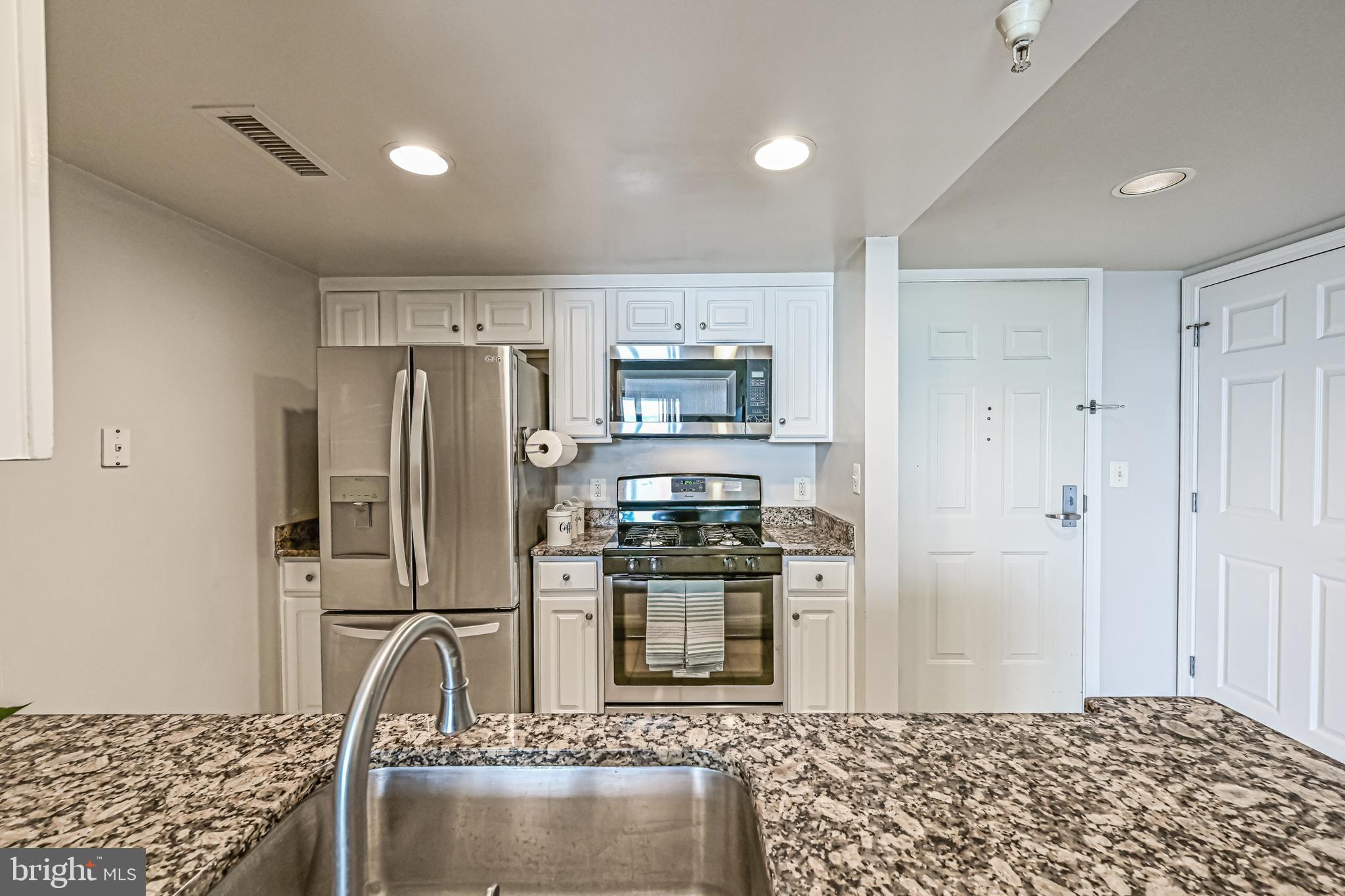 11710 Old Georgetown Road, Unit 1212 Rockville, MD 20852 - Photo 28 of 55 a kitchen with stainless steel appliances granite countertop a refrigerator and a stove top oven