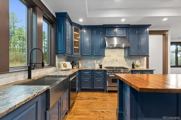 a kitchen with stainless steel appliances granite countertop sink stove top oven and cabinets