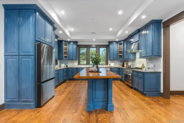 a kitchen with stainless steel appliances granite countertop sink stove refrigerator and cabinets