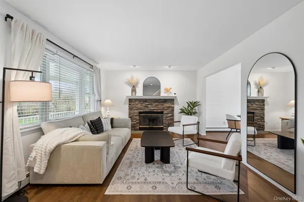 a living room with furniture a fireplace and a large window